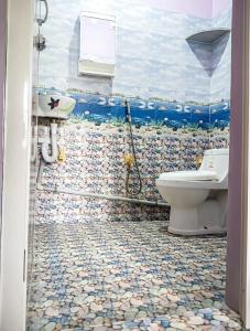 bagno con servizi igienici e murale dell'oceano di NAKSHATHRA Guest House 2BHK a Tiruvannāmalai