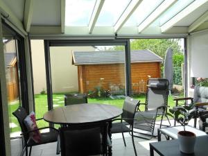un patio cubierto con mesa y sillas en Chalet near Cap Frehel with Coastal Views, en Fréhel