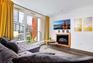 a living room with a couch and a fireplace at Stylish Condo in Downtown in Vancouver