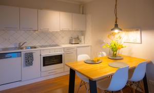 a kitchen with a wooden table and white cabinets at Passat in Westermarkelsdorf