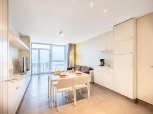 Una cocina y un comedor con mesa y sillas. en Apartment by Belgian Coast with Beach Views, en Oostduinkerke