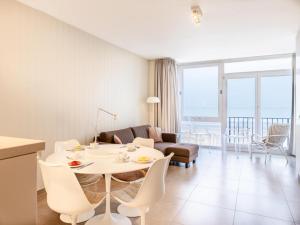 una sala de estar con una mesa y sillas en Apartment on Belgian Coast with Sea Views, en Oostduinkerke
