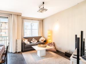 a living room with a couch and a table at Apartment by the Coast with Sunny Terrace in Oostduinkerke