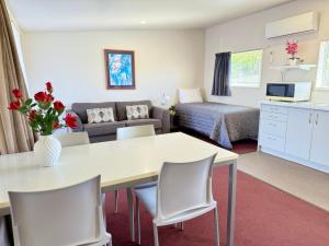 a small living room with a table and a couch at Morrinsville Motel in Morrinsville
