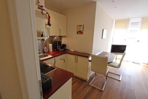 een keuken met een tafel en stoelen in een kamer bij Strandidyll, 54 - Typ A1 in Grömitz