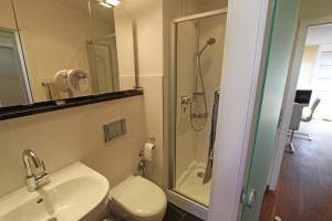 een badkamer met douche, wastafel en toilet bij Strandidyll, 54 - Typ A1 in Grömitz