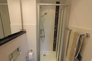 een badkamer met een douche met een glazen deur bij Strandidyll, 54 - Typ A1 in Grömitz +12 foto's