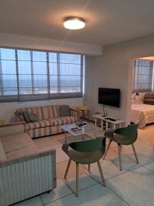 a living room with a couch and a tv at Apartamento Vacacional Playa Grande in Maiquetía