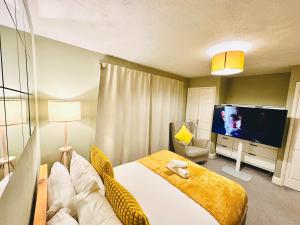 a bedroom with a bed and a flat screen tv at Opulent Marriott in London