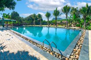 a large swimming pool with palm trees in the background at Dong Giao Bungalows Ninh Binh in Tam Ðiệp