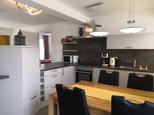 eine Küche mit weißen Schränken und einem Holztisch in der Unterkunft FeWo Prora - MeerSonneWind in Binz