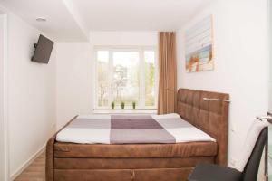 ein Schlafzimmer mit einem Bett und einem Fenster in der Unterkunft FeWo Prora - MeerSonneWind in Binz