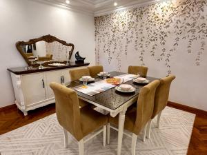 a dining room table with chairs and a mirror at Vintage Charm & Spacious Comfort in Zayed 2000 - only families & single travelers in Sheikh Zayed