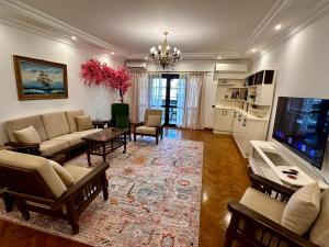 a living room with a couch and a tv at Vintage Charm & Spacious Comfort in Zayed 2000 - only families & single travelers in Sheikh Zayed