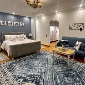 a bedroom with a bed and a couch and a table at Vintage Charm & Spacious Comfort in Zayed 2000 - only families & single travelers in Sheikh Zayed