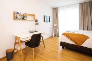 ein Hotelzimmer mit Schreibtisch und Bett in der Unterkunft Ferienwohnung "Pfänder" in Friedrichshafen