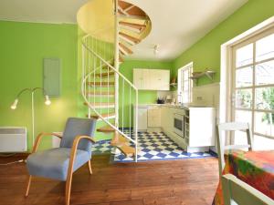 RoggowにあるIdyllisches Ferienhaus mit Terrasse in Rerikの緑の壁とらせん階段のあるキッチン