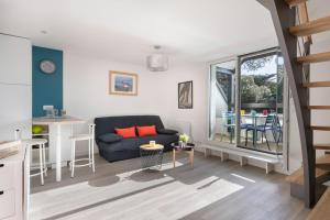 a living room with a couch and a table at Appartement vue mer et les pieds dans l'eau! in Saint-Sébastien +6 photos