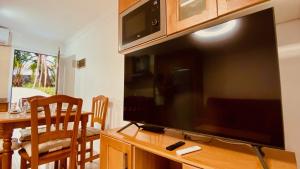 A television and/or entertainment centre at Comfortable flat close to the beach