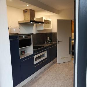 a blue kitchen with a sink and a stove at Ferienwohnung Schloßberg 2 in Peiting