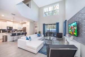 a living room with a white couch and a tv at Fabulous Villas 5 minutes away from Disney! in Kissimmee