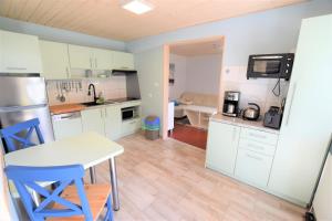 eine Küche mit weißen Schränken und einem Tisch und Stühlen in der Unterkunft Bungalow Janik in Dahme