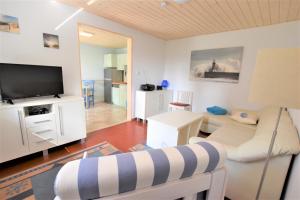 ein Wohnzimmer mit Sofa und Fernseher in der Unterkunft Bungalow Janik in Dahme