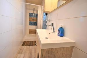 ein weißes Badezimmer mit Waschbecken und Dusche in der Unterkunft Bungalow Janik in Dahme