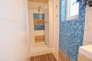 ein Badezimmer mit einer Dusche mit blauen Fliesen in der Unterkunft Bungalow Janik in Dahme + 5 Fotos