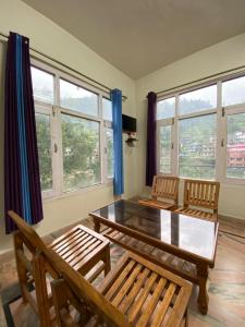 a living room with a table and chairs and windows at Heaven87 Homestay in Kāndi