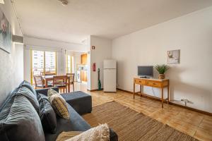 un salon avec un canapé et une table avec une télévision dans l'établissement BeGuest Clube Praia da Rocha Apartment, à Praia da Rocha 3 autres photos