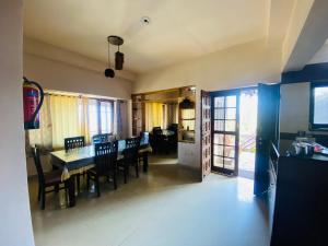 a kitchen and dining room with a table and chairs at Him Monal Homestay in Mukteshwar