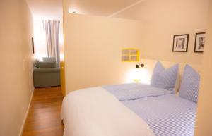 a bedroom with a bed with blue and white sheets at Levanto in Westermarkelsdorf