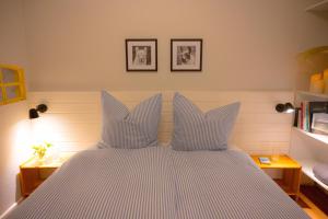 a bed with blue and white striped sheets and pillows at Levanto in Westermarkelsdorf +15 photos
