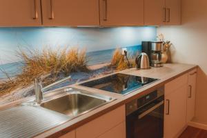 a kitchen with a sink and a counter top at Sahel in Westermarkelsdorf +11 photos