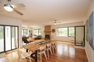 Un comedor y una sala de estar con mesa y sillas. en Claystone - walking distance to the beach, en Aireys Inlet