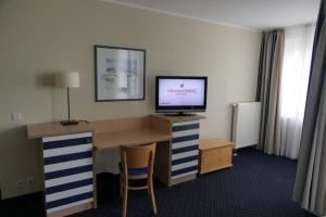 a hotel room with a desk with a television on it at SUITE AN DER SEEBRÜCKE mit seitlichem Meerblick in Zingst