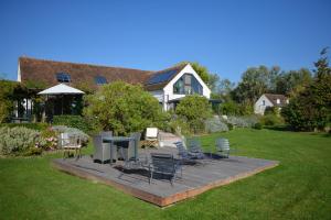 a yard with chairs and tables and a house at Domaine de Bellevue, The Originals Relais (Relais du Silence) in Neufmoutiers-en-Brie