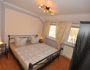 ブレーメンにあるDeluxe Apartments Bremen Typ Dのベッドと2つの窓がある寝室 +5枚の写真