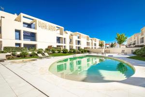 uma piscina em frente a um prédio em BeGuest Only Good Vibes - Cabanas em Tavira