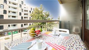 a table with a bowl of fruit on a balcony at HOMEY PURITY / NEW / Parking gratuit / Proche Tram / Aux portes de Genève in Ambilly