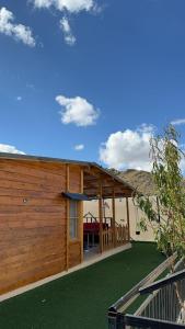 كوخ الوهط الريفي في الطائف: مبنى خشبي كبير مع حديقة خضراء