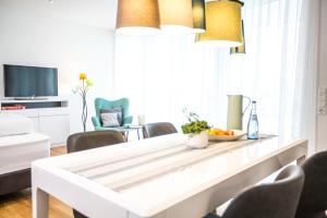 ein Wohnzimmer mit einem weißen Tisch und Stühlen in der Unterkunft Ferienwohnung "Höchsten" in Friedrichshafen