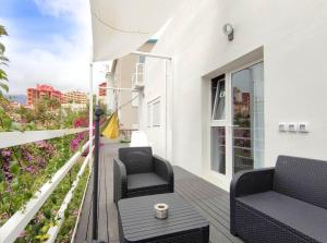 ein Balkon mit zwei Stühlen und einem Tisch in der Unterkunft Fantastico 4 - a45335 in Puerto de la Cruz