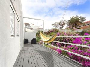 eine Hängematte auf dem Balkon eines Hauses mit Blumen in der Unterkunft Fantastico 4 - a45335 in Puerto de la Cruz