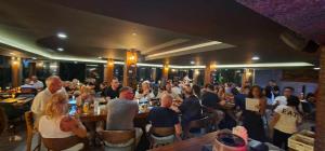 a group of people sitting at tables in a restaurant at Oceanview Bungalows by EAT in Karon Beach