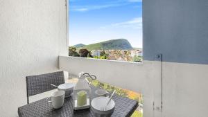 balkon ze stołem z kubkami i oknem w obiekcie HOMEY COLIBRI - New / Free parking/ Proche Gare Annemasse / Aux portes de GenèveGenève w mieście Annemasse