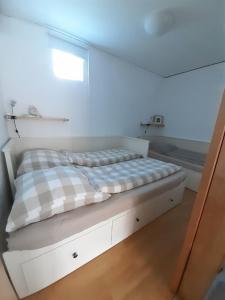 a bed in a white room with a window at Bungalow 2702 in Tossens in Tossenserdeich +9 photos
