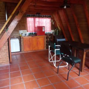 a kitchen with a table and chairs in a attic at Alpina para parejas en Lujan in Luján