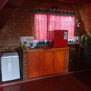 a kitchen with a microwave and a red refrigerator at Alpina para parejas en Lujan in Luján